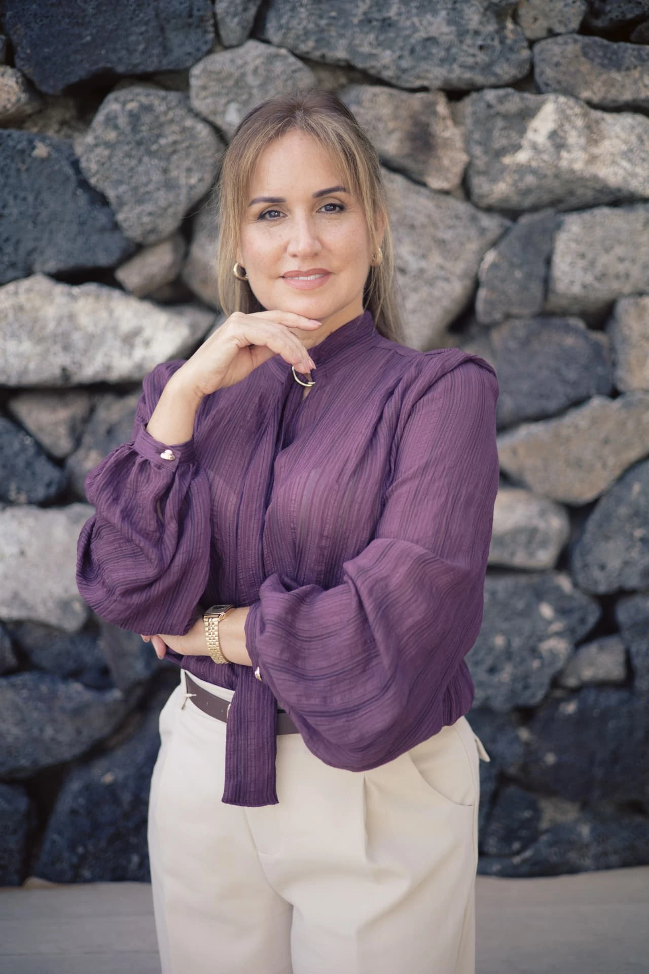 Retrato de Fayna Curbelo ante un muro de piedra volcánica.
